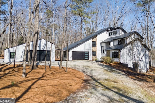 exterior space with an attached garage and dirt driveway