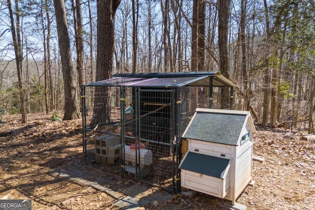 view of poultry coop featuring a view of trees