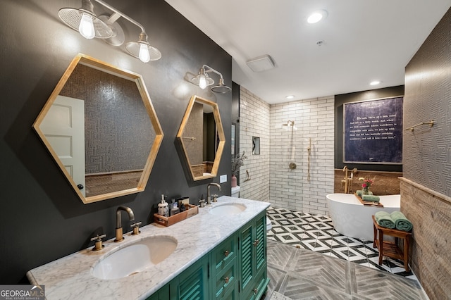 full bathroom featuring double vanity, a walk in shower, a freestanding bath, and a sink