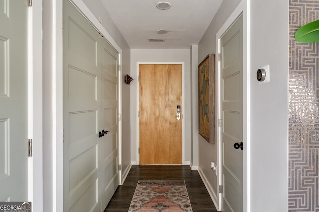 entryway featuring visible vents, baseboards, and dark wood-style flooring