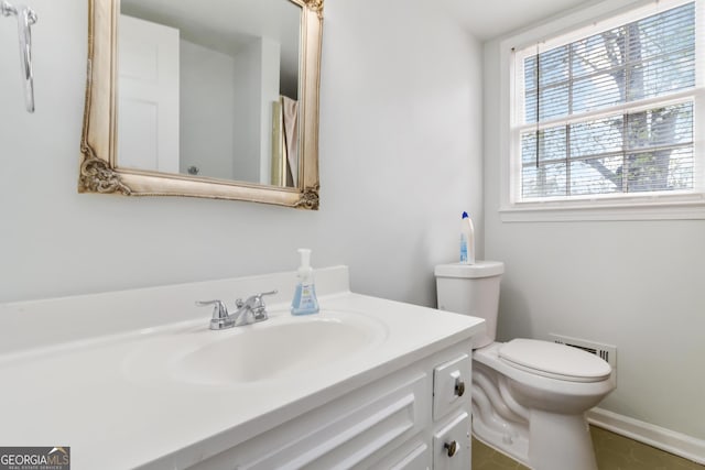 bathroom with vanity, toilet, and baseboards