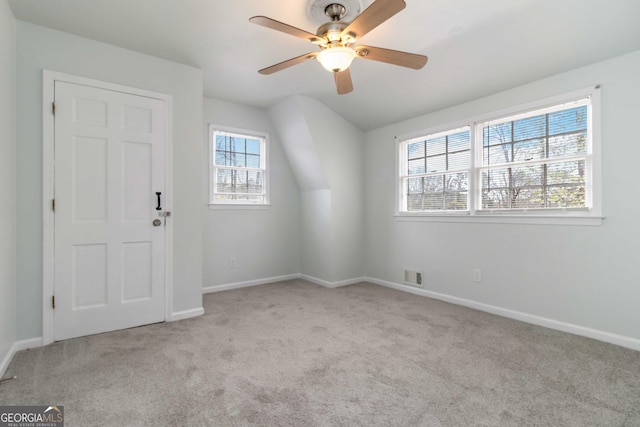 carpeted spare room with visible vents, ceiling fan, and baseboards