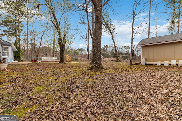 view of yard featuring an outdoor structure and fence