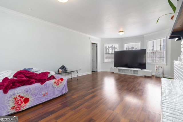 bedroom featuring baseboards, wood finished floors, and crown molding