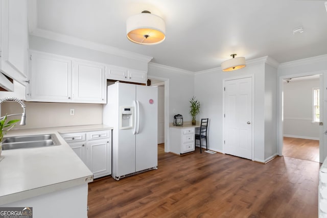 kitchen with dark wood-style flooring, a sink, light countertops, white refrigerator with ice dispenser, and white cabinetry