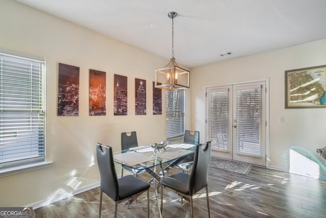 dining area with visible vents, baseboards, french doors, an inviting chandelier, and wood finished floors