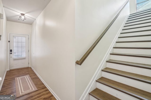 entryway with stairs, wood finished floors, and baseboards