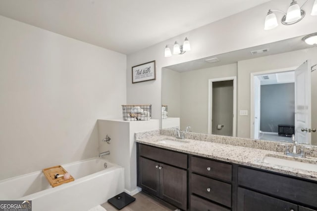 full bathroom featuring a garden tub, double vanity, visible vents, and a sink