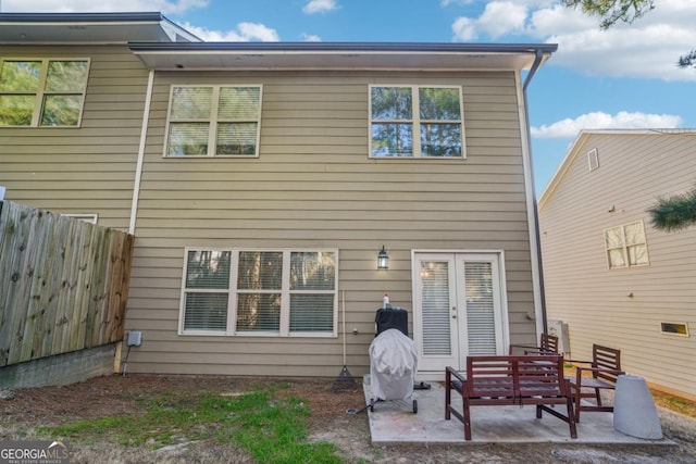 rear view of house with a patio area and fence