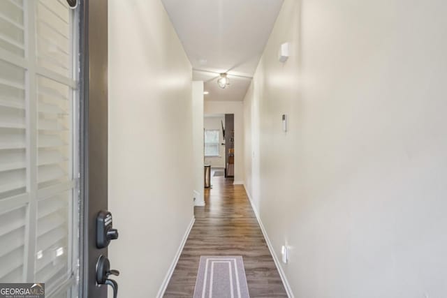 hall with dark wood-style floors and baseboards