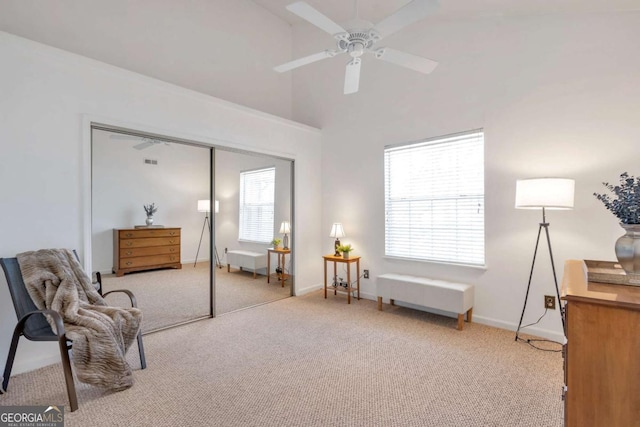 sitting room with a high ceiling, baseboards, carpet floors, and ceiling fan