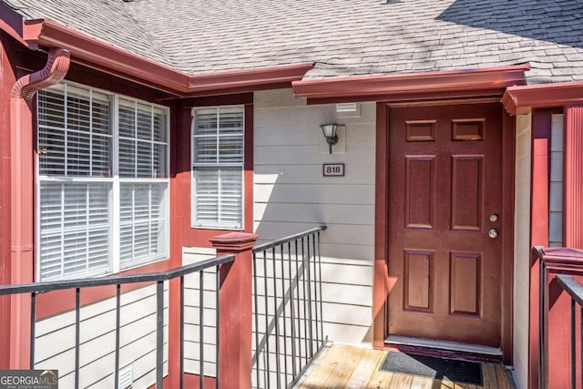 entrance to property with a shingled roof