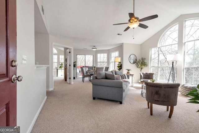 living room with visible vents, baseboards, light colored carpet, ceiling fan, and vaulted ceiling