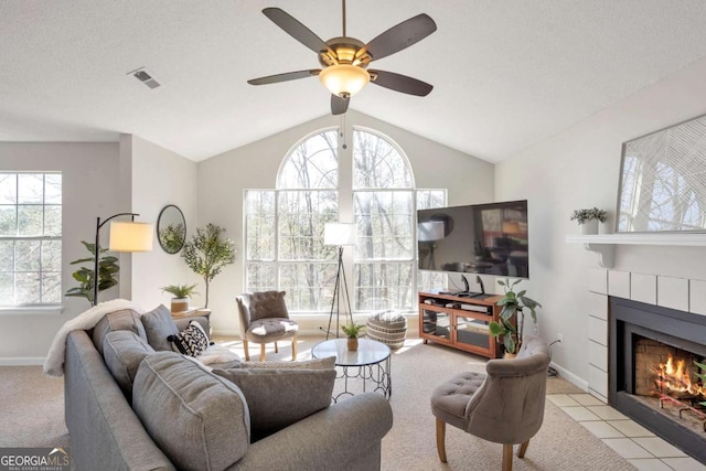 living room featuring lofted ceiling, a fireplace, visible vents, and baseboards