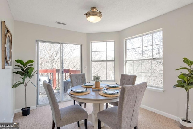 dining area with visible vents, baseboards, and carpet