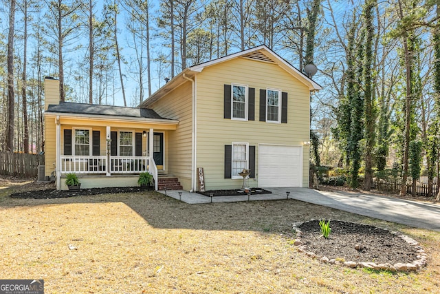 split level home featuring an attached garage, covered porch, driveway, and fence