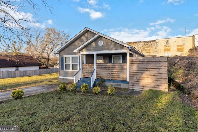 view of front of home featuring entry steps, a front lawn, fence, and crawl space