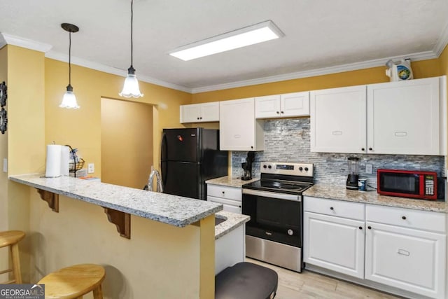 kitchen featuring a peninsula, stainless steel electric range, freestanding refrigerator, white cabinetry, and a kitchen breakfast bar