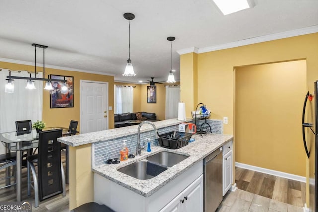 kitchen with crown molding, white cabinets, appliances with stainless steel finishes, and a sink