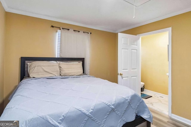 bedroom with attic access, wood finished floors, baseboards, and ornamental molding