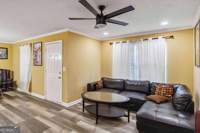 living room with crown molding, wood finished floors, baseboards, and a textured ceiling