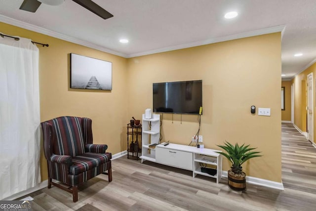 sitting room featuring recessed lighting, crown molding, baseboards, and wood finished floors