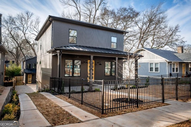 view of front of home with a fenced front yard, metal roof, and a standing seam roof