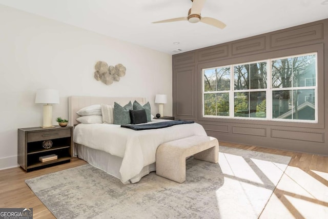 1103 Boulevard Dr SE, Atlanta, GA 30317 - bedroom with light wood-type flooring, ceiling fan, and a decorative wall