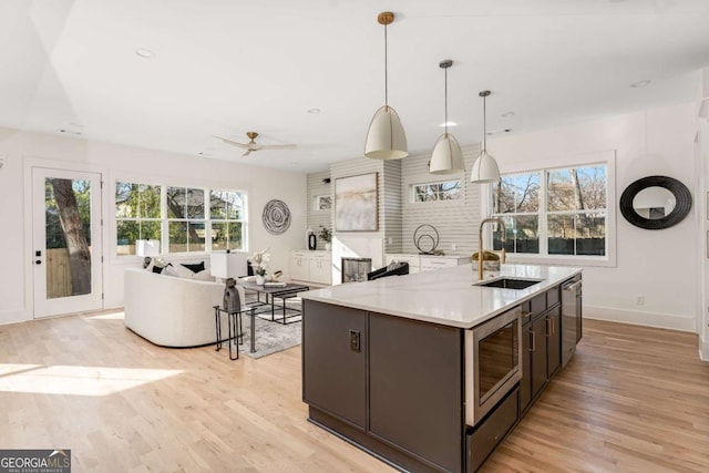 1103 Boulevard Dr SE, Atlanta, GA 30317 - kitchen featuring dark brown cabinetry, light wood-style flooring, stainless steel appliances, and a sink