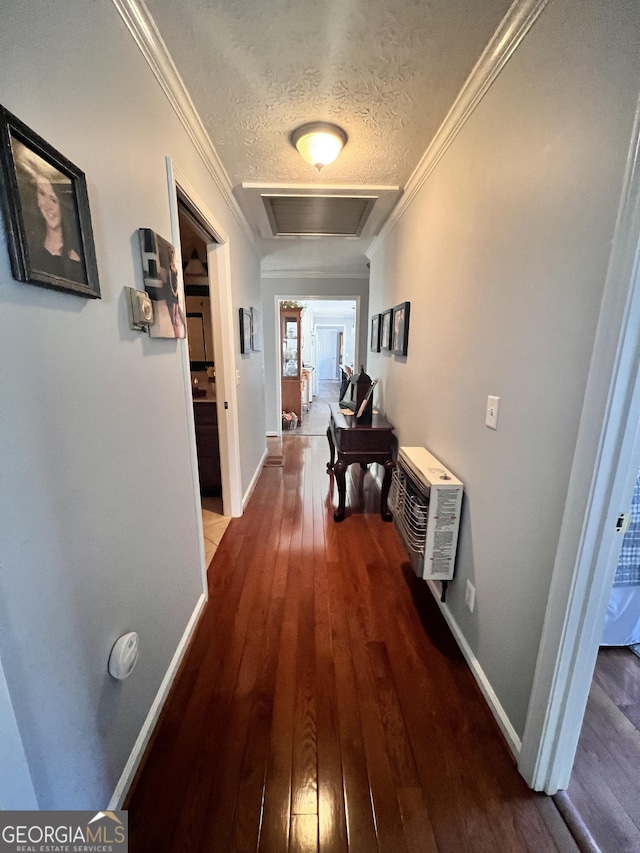 hallway with crown molding, attic access, hardwood / wood-style flooring, and a textured ceiling