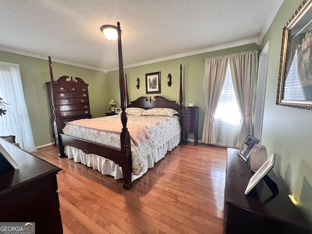 bedroom featuring ornamental molding, a textured ceiling, and wood-type flooring