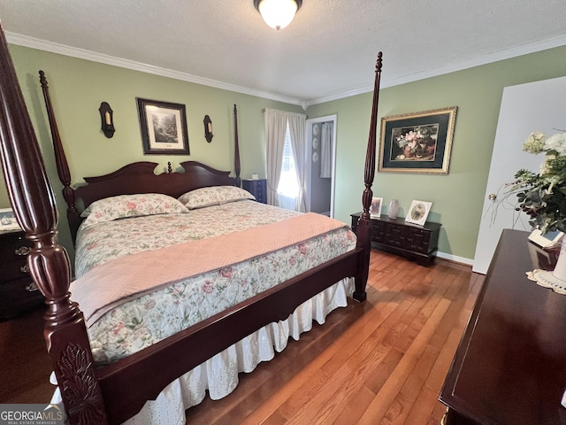 bedroom with hardwood / wood-style floors, crown molding, and a textured ceiling