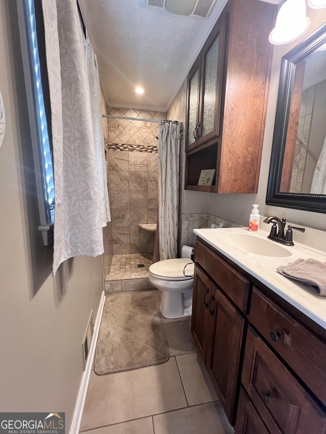 full bath featuring vanity, visible vents, tiled shower, a textured ceiling, and toilet