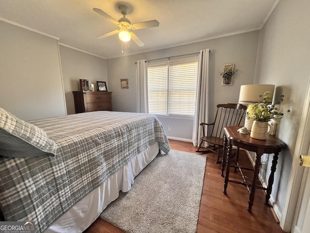 bedroom with ceiling fan, wood finished floors, baseboards, and ornamental molding