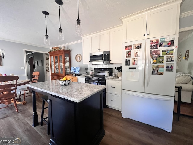 kitchen with dark wood-type flooring, crown molding, white fridge with ice dispenser, stainless steel microwave, and a center island