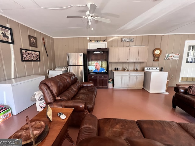 living room with ceiling fan, washer / clothes dryer, and finished concrete flooring