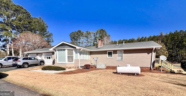 view of front of property with a garage, concrete driveway, and a chimney