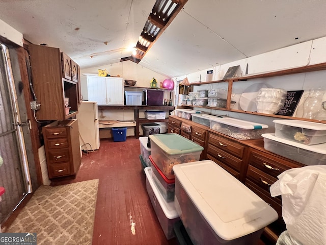 kitchen with open shelves, lofted ceiling, and dark wood finished floors