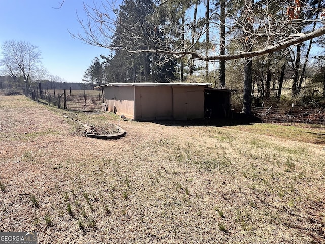 view of yard featuring an outbuilding, a pole building, and fence