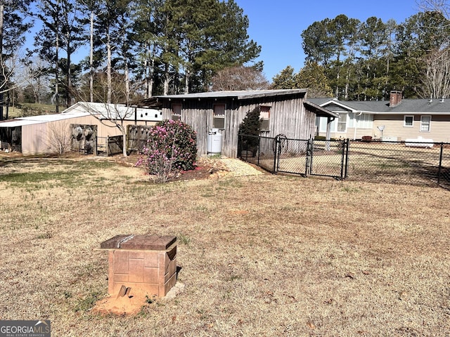 exterior space featuring a gate, fence, and a lawn