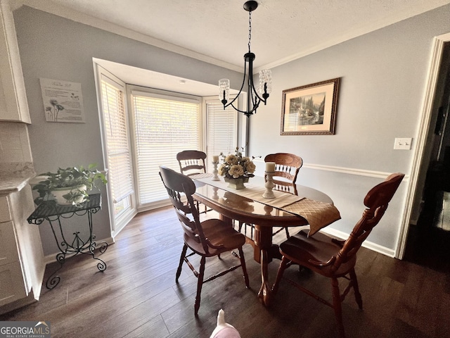 dining space featuring ornamental molding, baseboards, and wood finished floors