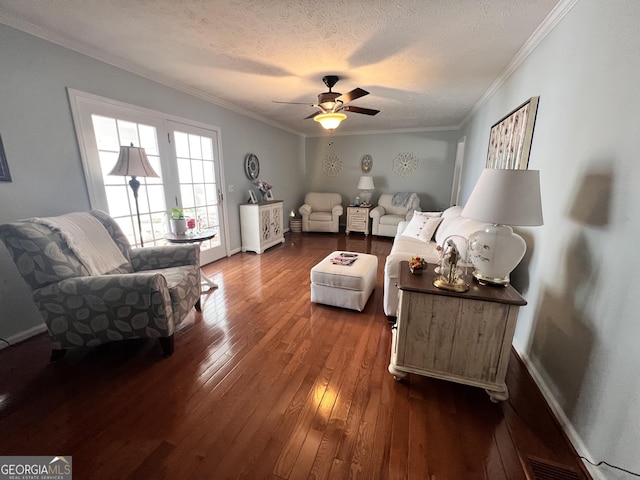 living area with a textured ceiling, ceiling fan, dark wood-style flooring, and ornamental molding