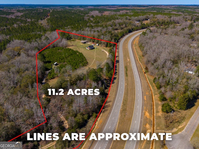 birds eye view of property featuring a wooded view