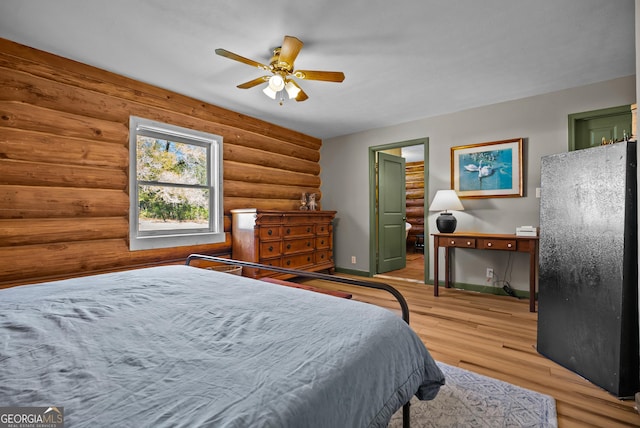 bedroom featuring a ceiling fan, baseboards, light wood-type flooring, and log walls