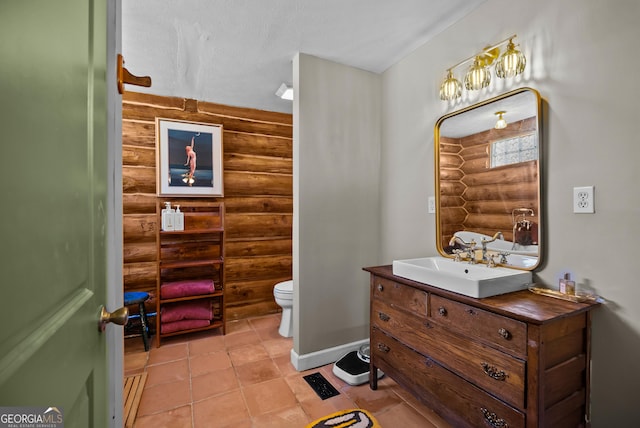 bathroom with baseboards, toilet, vanity, and tile patterned flooring