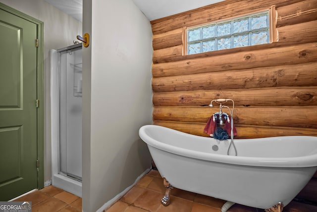 bathroom featuring log walls, a freestanding bath, a shower stall, and tile patterned flooring