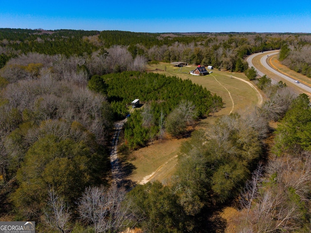 birds eye view of property featuring a view of trees