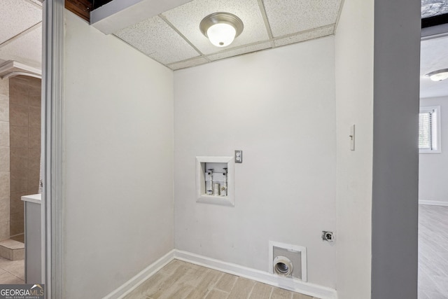 washroom featuring electric dryer hookup, baseboards, light wood-style floors, and washer hookup