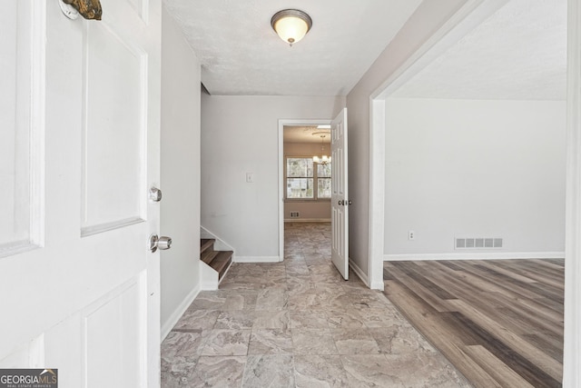 foyer entrance with stairway, baseboards, and visible vents