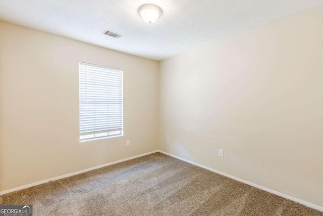 carpeted empty room with visible vents and baseboards